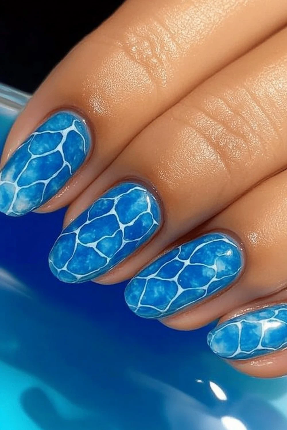 Blue water ripple nail design with white highlights, creating a realistic swimming pool effect.