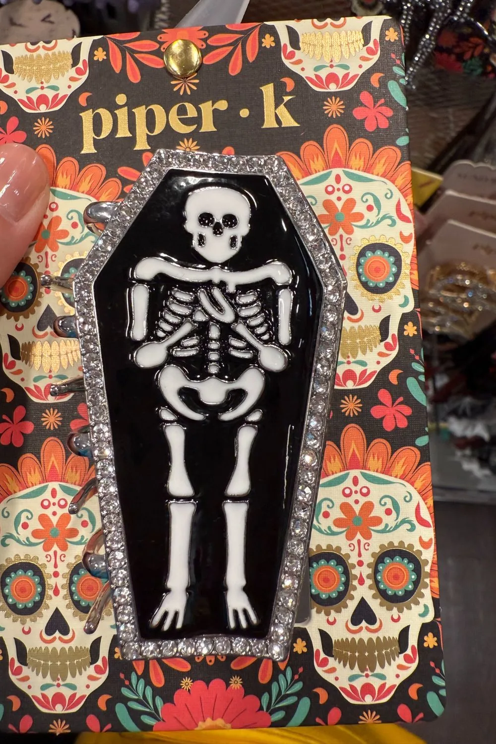 Black and white skeleton coffin hair clip with rhinestone border.