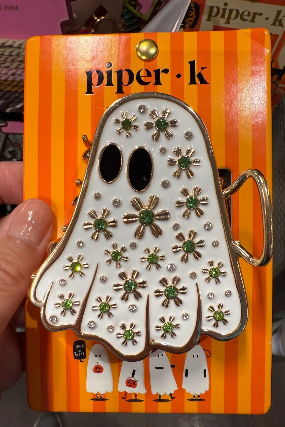 White ghost hair clip with green jeweled flower details.