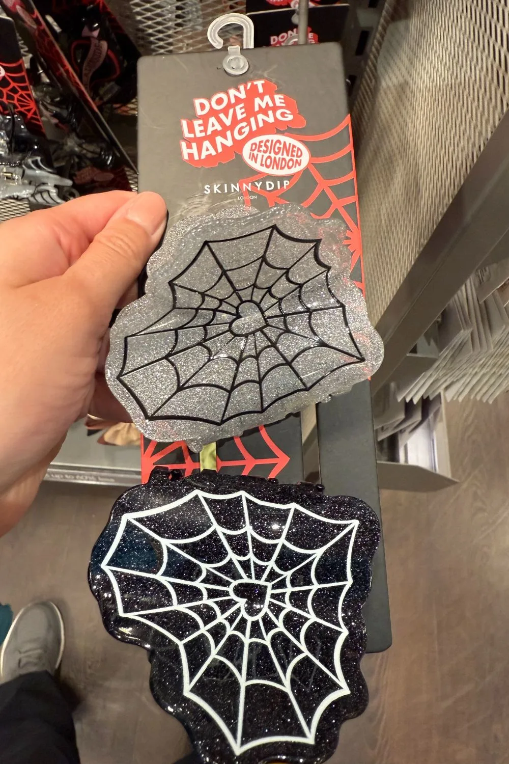 Black and silver glitter spiderweb hair clips with heart-shaped web design.