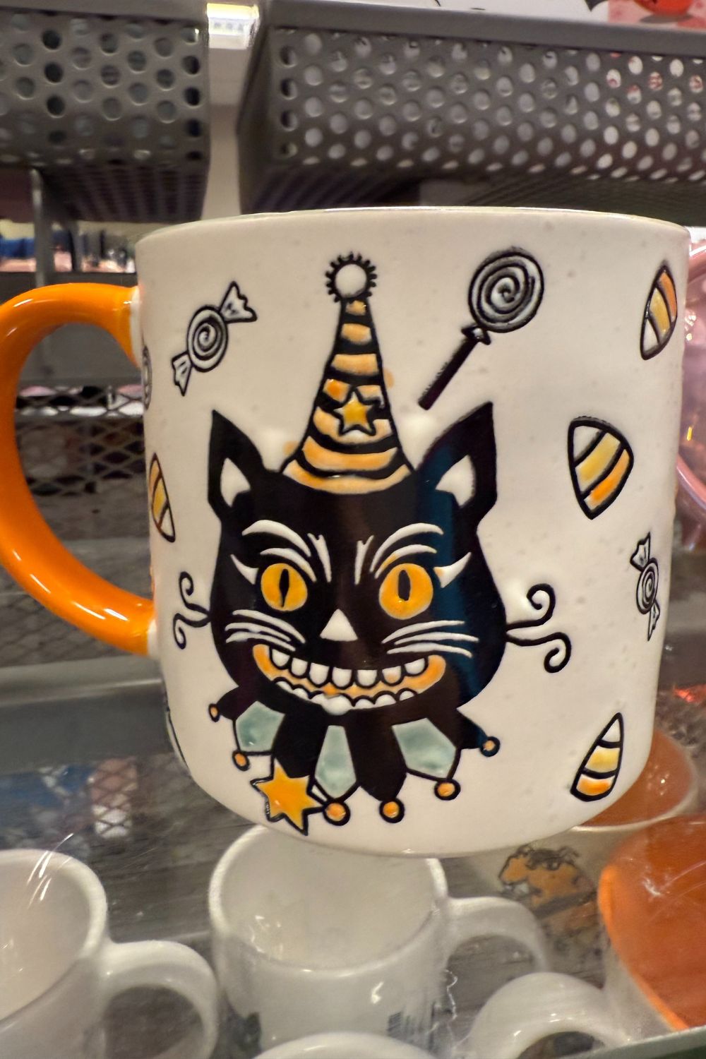 Halloween mug with black cat in party hat surrounded by candy from TK Maxx.
