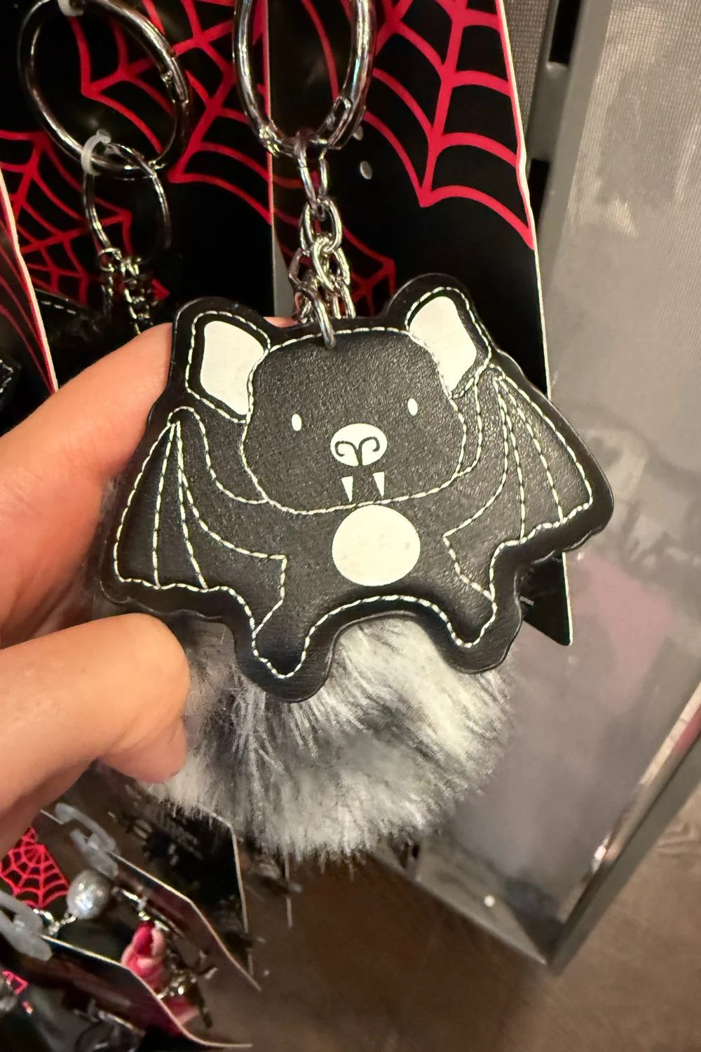 Halloween bag charm shaped like a bat with a grey pompom.