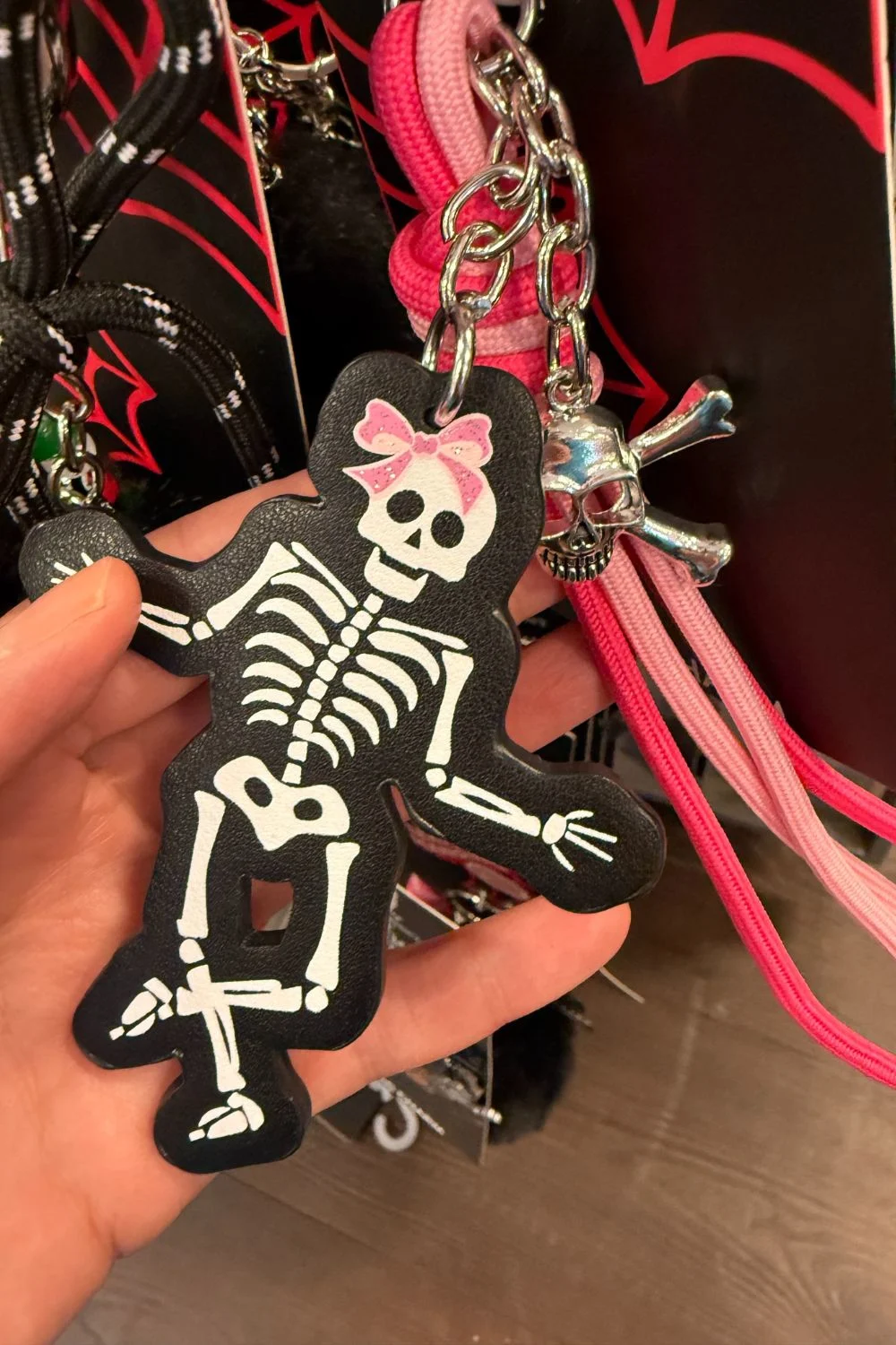 Halloween bag charm shaped like a skeleton with a pink bow.