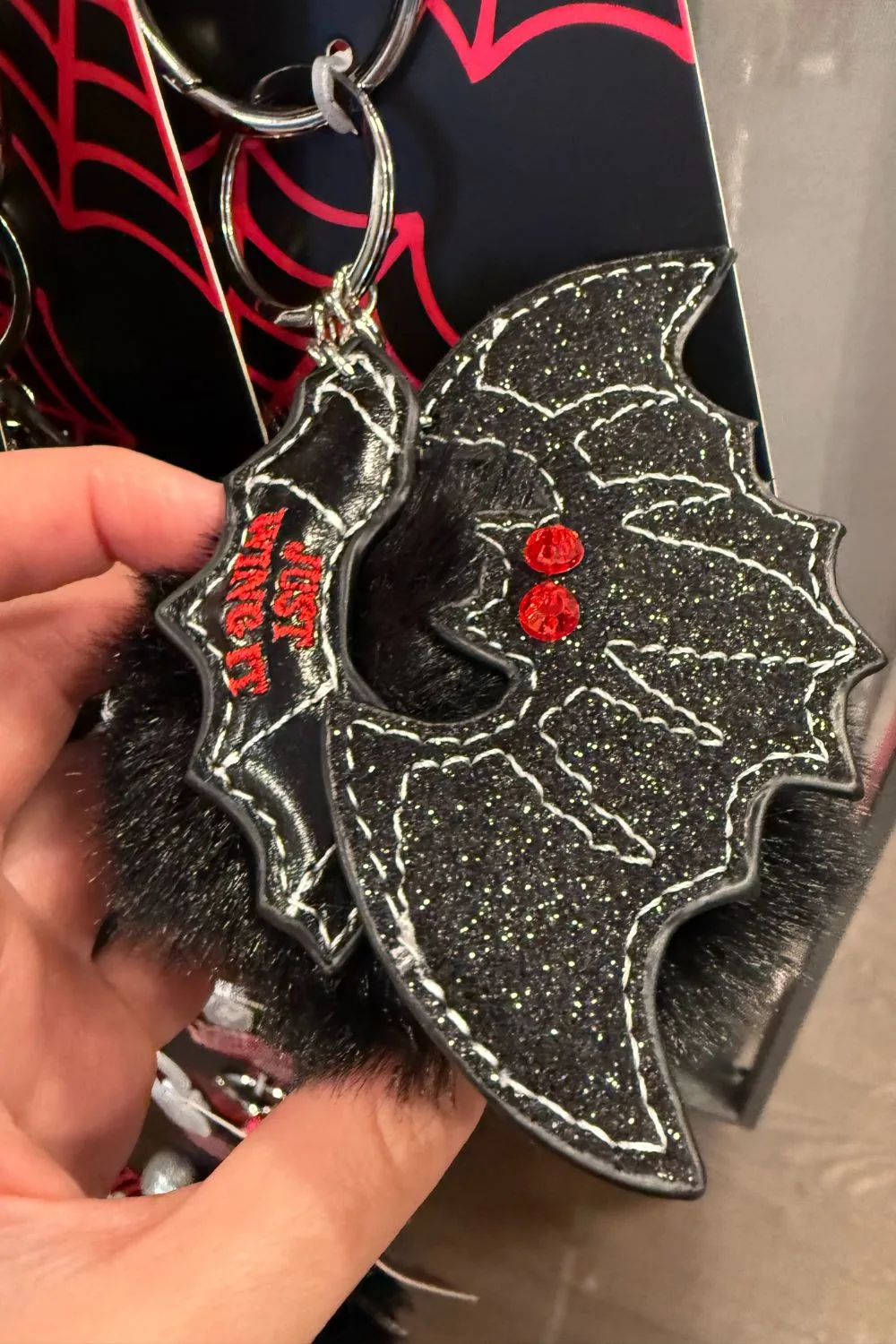 Halloween bag charm with black glitter bat and red gem eyes.