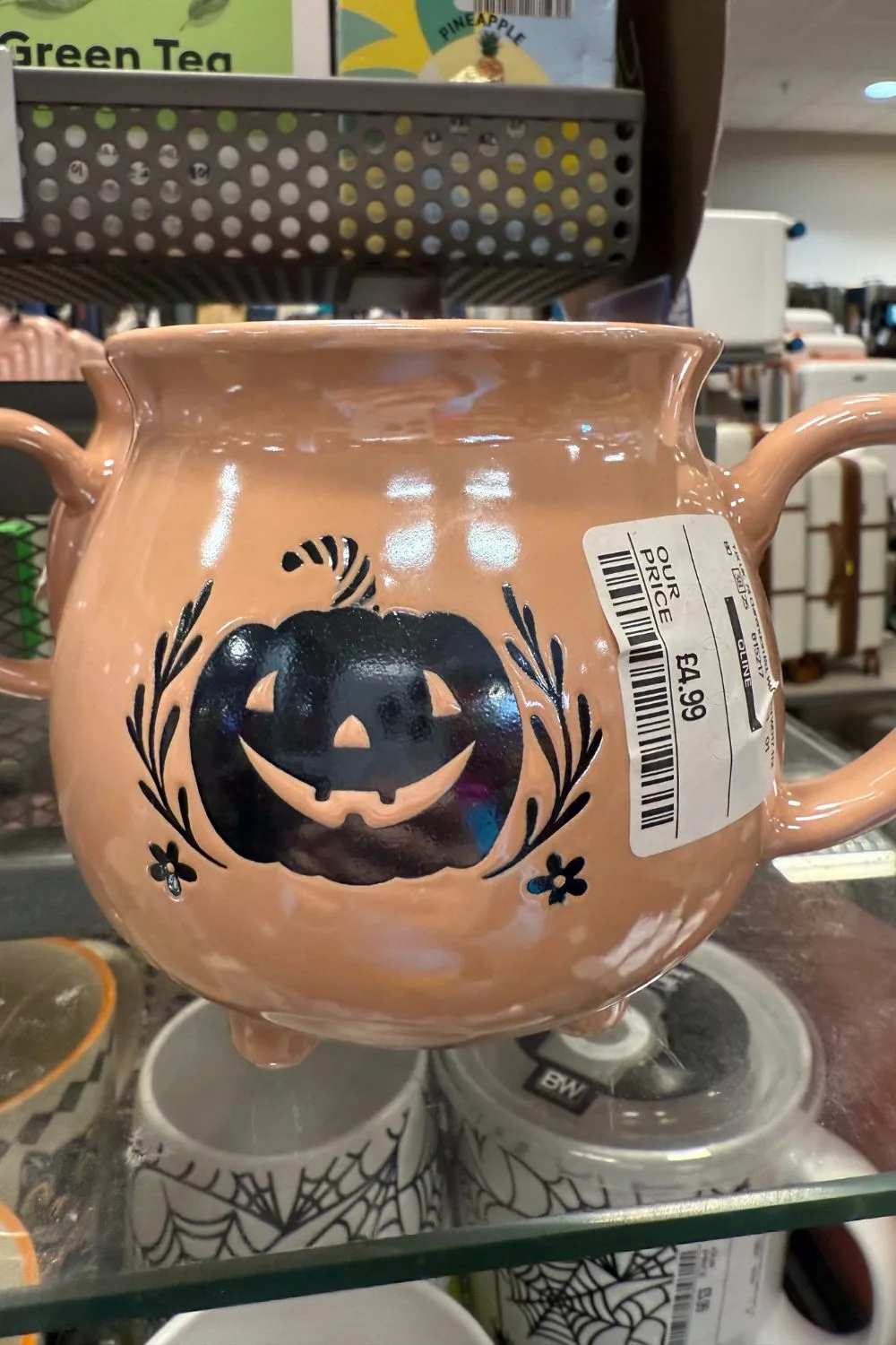 Peach cauldron-style mug with black pumpkin design from TK Maxx.