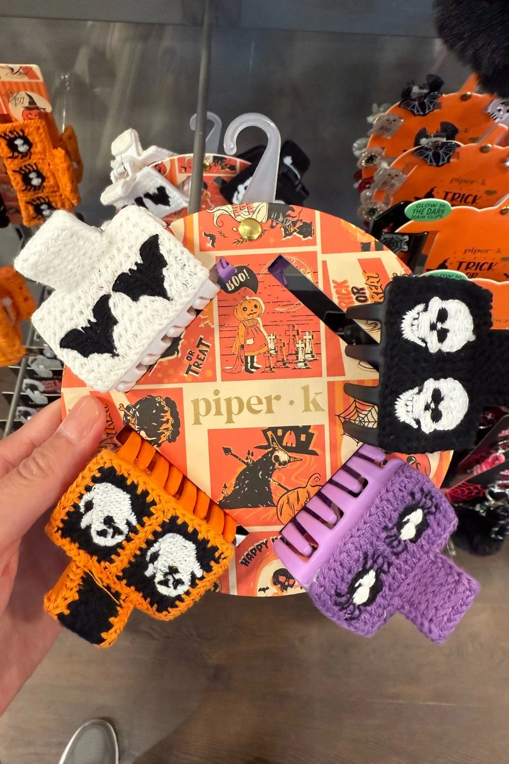 Set of colorful crocheted Halloween hair clips with skull, bat, and pumpkin designs.