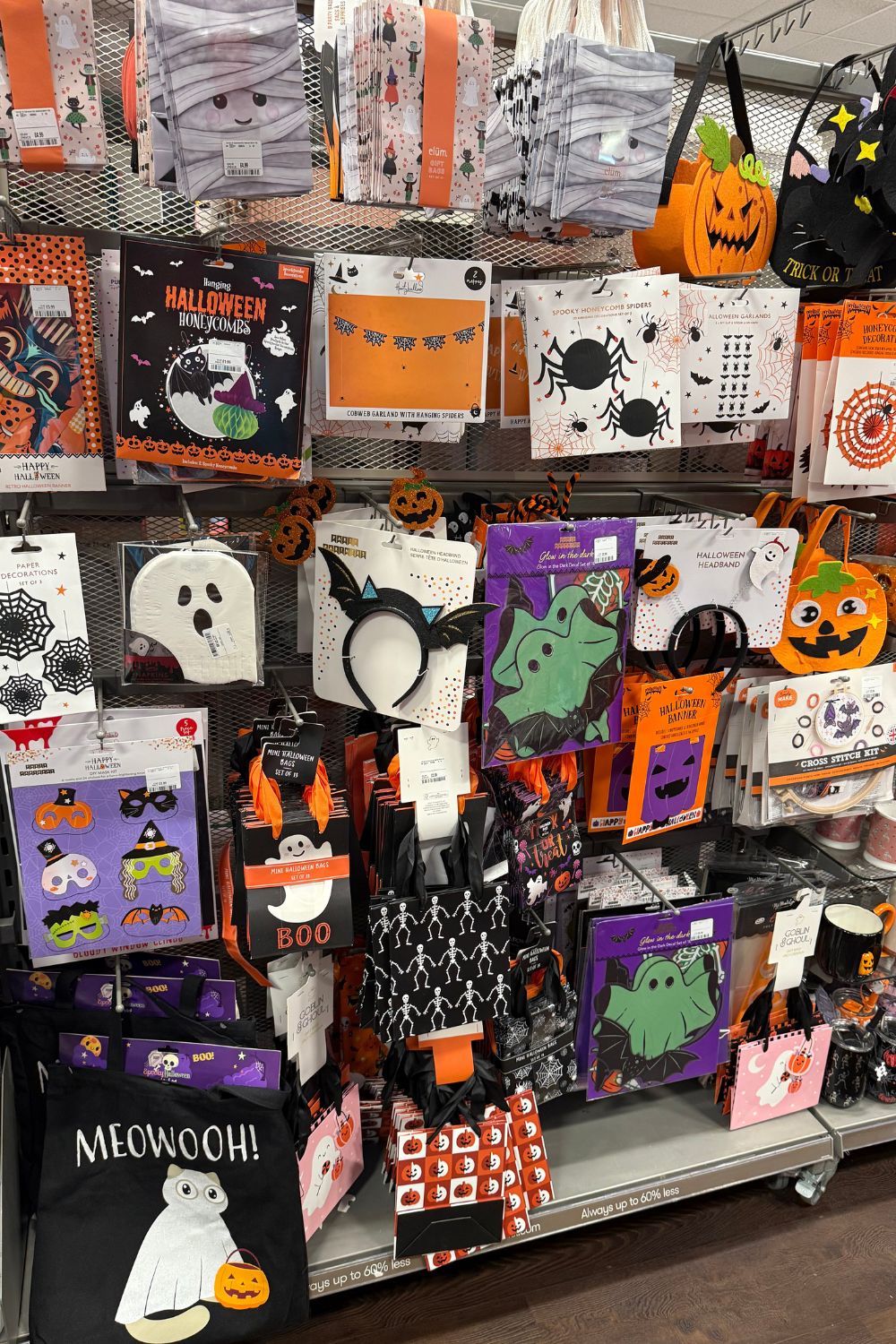 Halloween display at TK Maxx featuring trick-or-treat bags, spooky masks, paper decorations, and themed headbands.